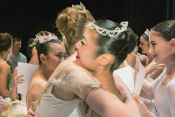 support the RAD - Royal Academy of Dance two ballerinas hugging backstage after performance