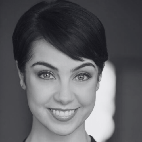 Black and white headshot of a smiling woman with short dark hair looking at the camera